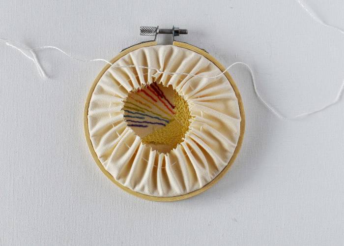 Pull the ends of the threads to gather the fabric